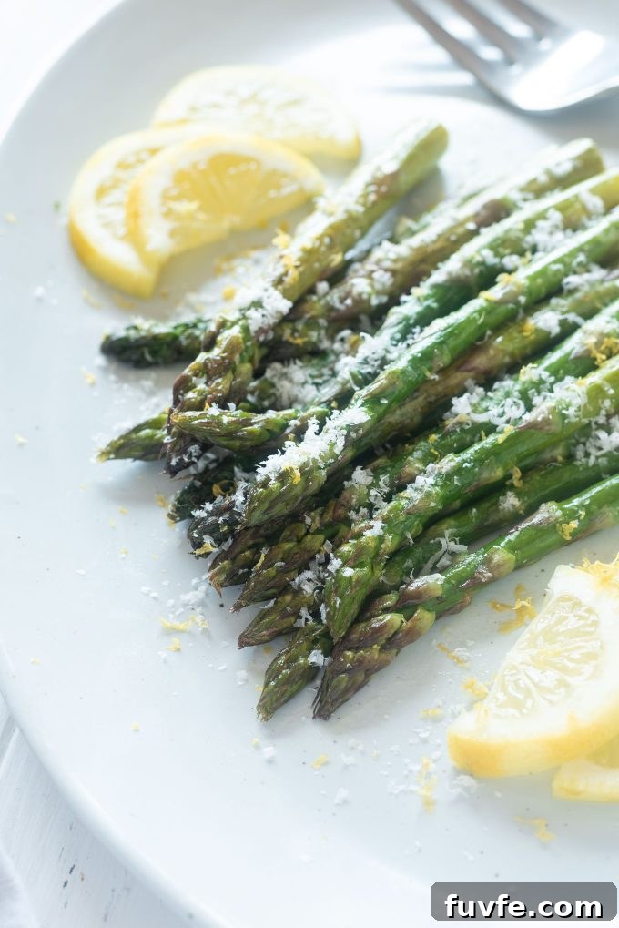 Roasted asparagus on a platter with parmesan cheese on top