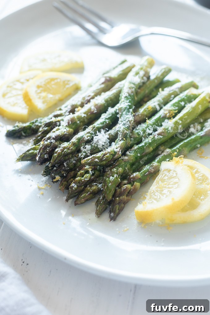Crispy Oven Roasted Asparagus with Lemon and Garlic 3 Oven roasted asparagus on a platter with lemon slices