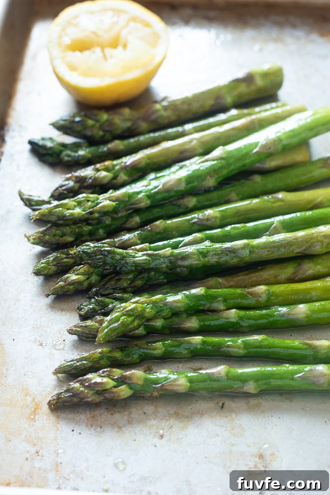 Crispy Oven Roasted Asparagus with Lemon and Garlic 6 Oven roasted asparagus on a sheet pan with lemon