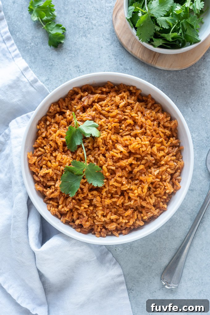 Easy Mexican rice in a serving bowl topped with cilantro sprig