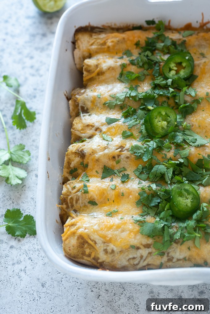 Green enchiladas in a baking dish with chopped cilantro