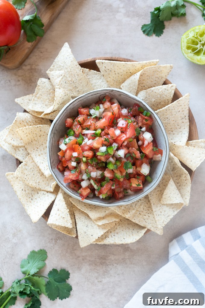 Homemade pico de gallo in a bowl surrounded by tortilla chips