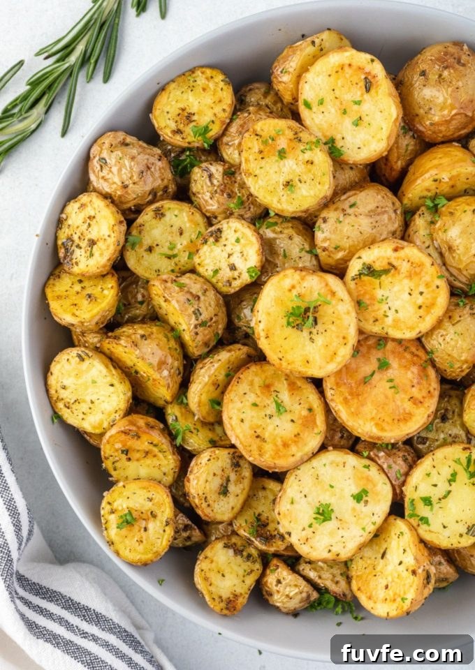 Crispy Air Fryer Potatoes with Garlic and Herbs 2 Air fryer potatoes in a bowl with rosemary