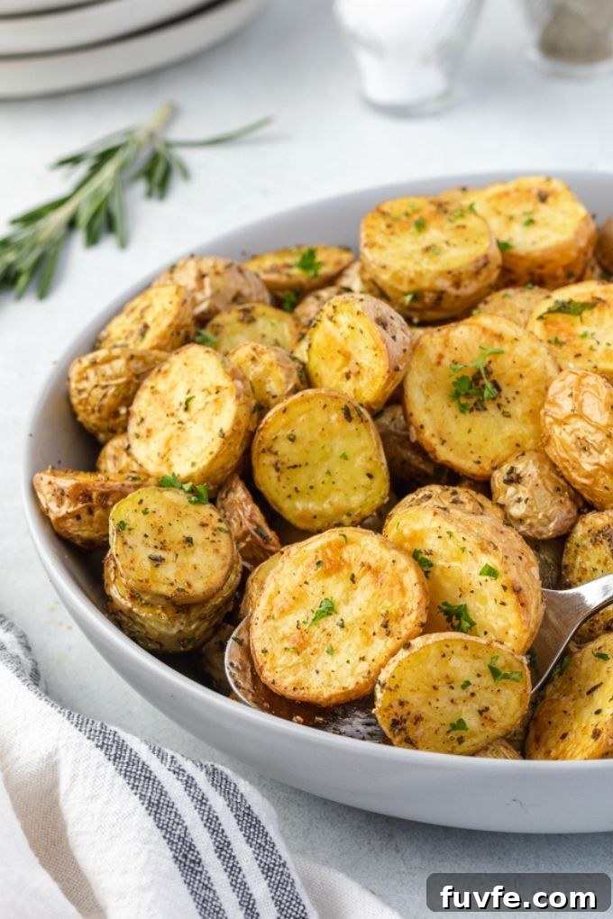 Crispy Air Fryer Potatoes with Garlic and Herbs 6 Air fryer roasted potatoes in a bowl with rosemary