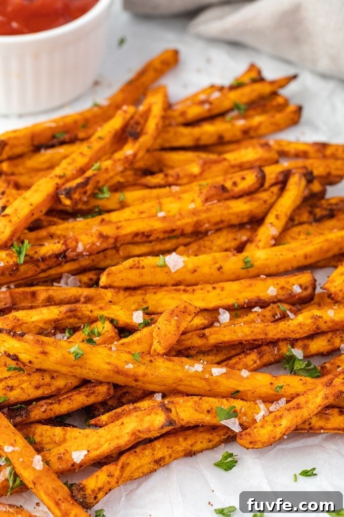 Air fryer sweet potato fries topped with flaky sea salt and parsley.