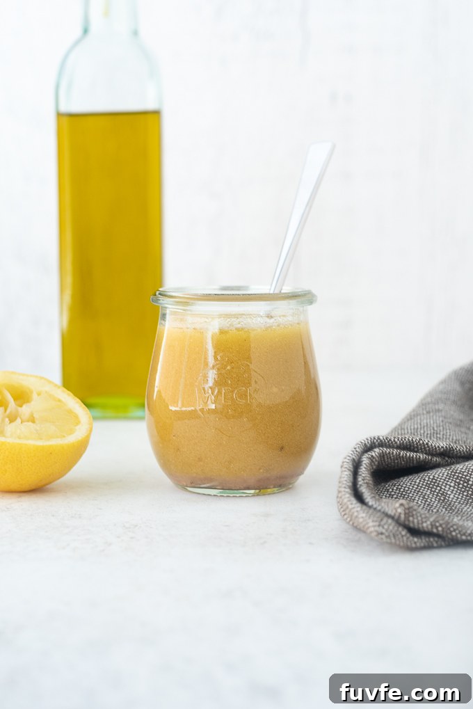Red wine vinaigrette in a jar with olive oil and lemon aside