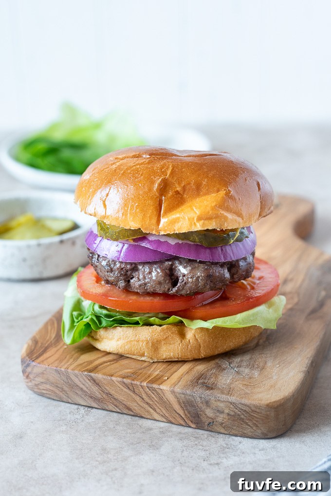 Air fryer hamburgers on a cutting board with condiments