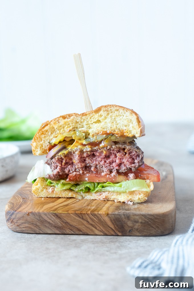 Juicy Air Fryer Hamburgers Recipe for Tender, Crispy Burgers 8 Air fryer hamburger cut in half on a cutting board