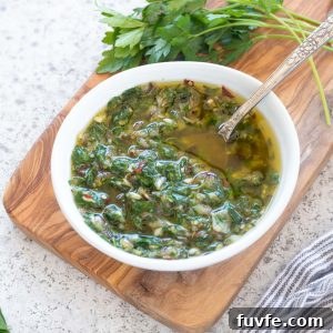 Chimichurri sauce in a bowl with a spoon inside