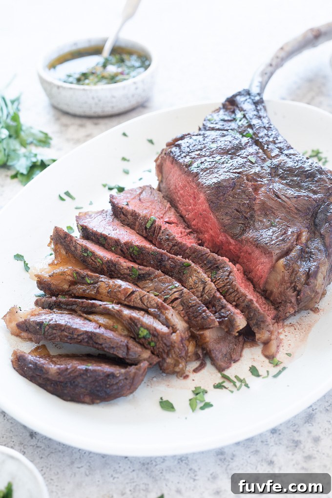 Grilled tomahawk steak sliced on a white platter