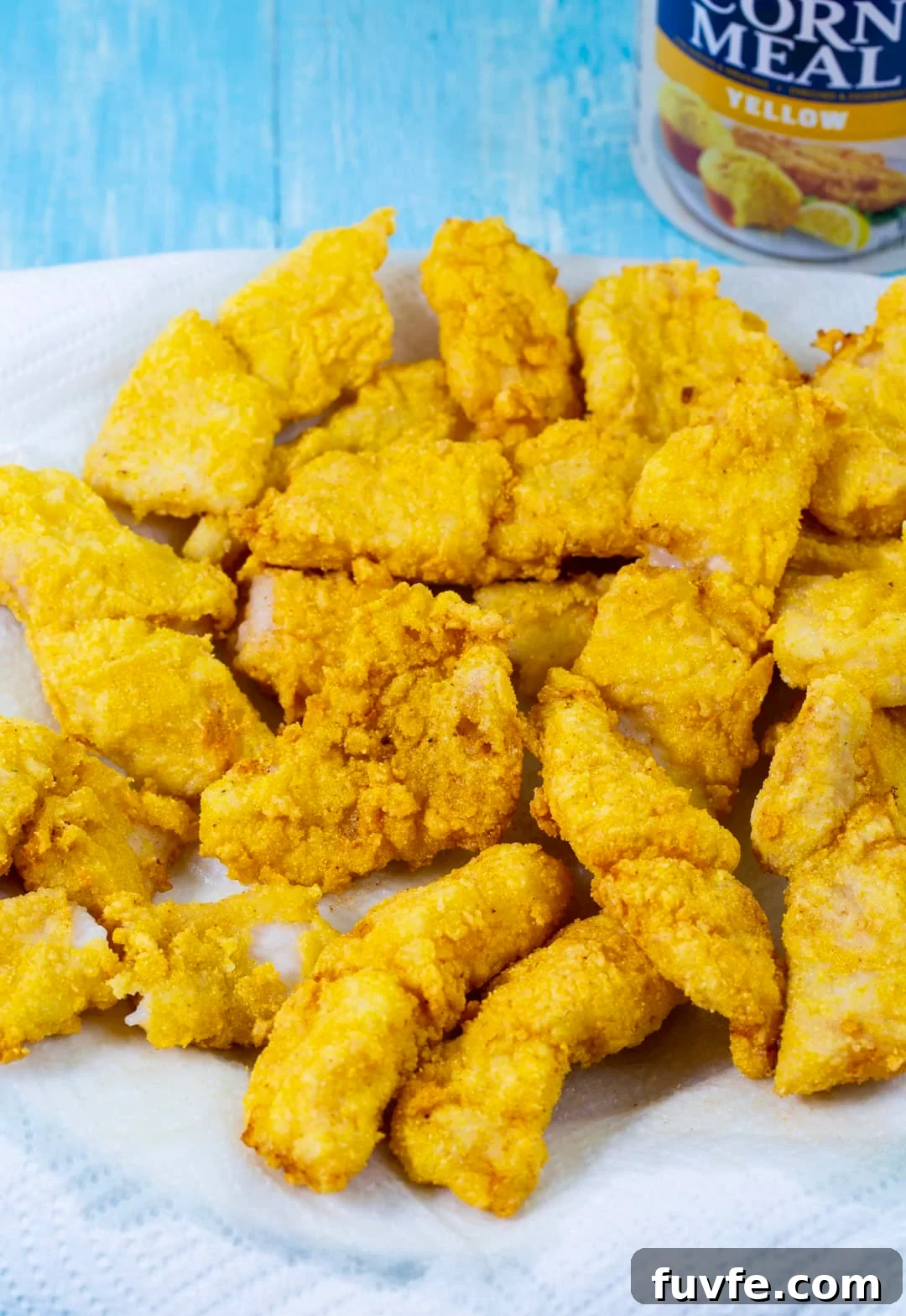 Fried catfish pieces on paper towel-lined plate.