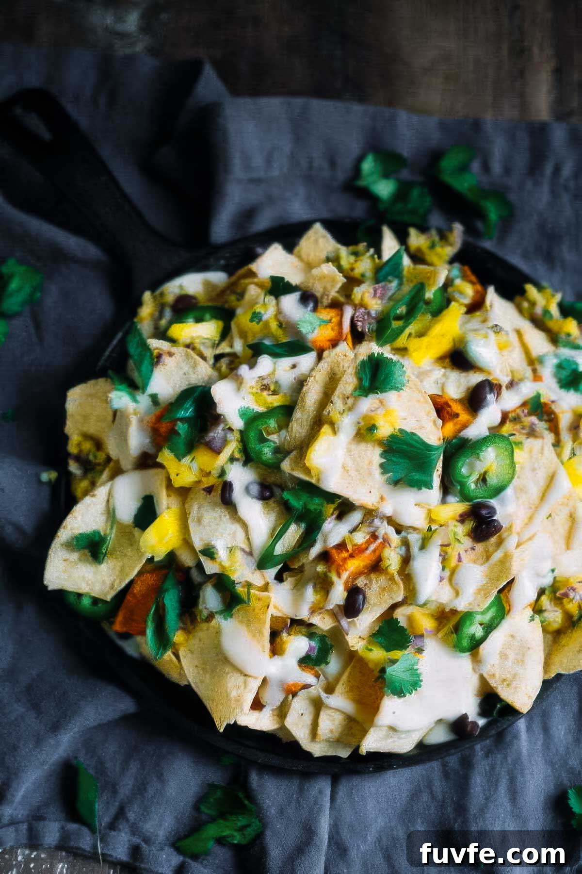 a plate of sweet potato nachos on a black linen towel