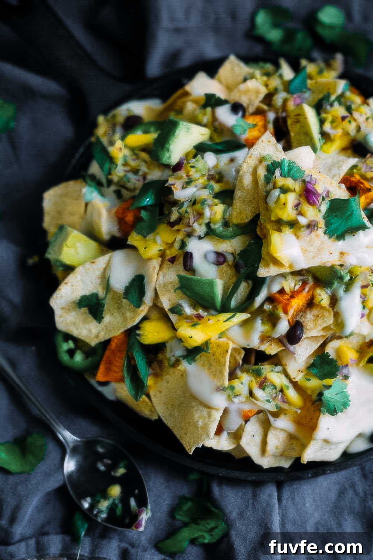 a plate of sweet potato nachos on a black linen towel