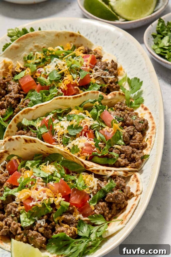 Quick Ground Beef Tacos Recipe for Weeknights 7 Ground beef tacos garnished with cilantro and lime.