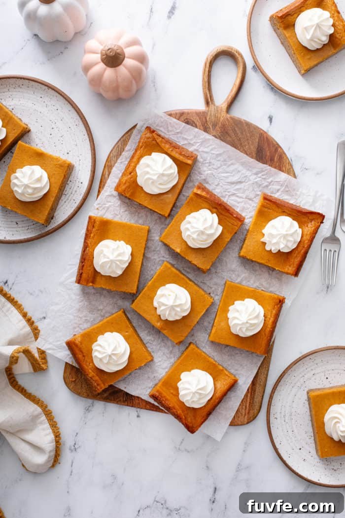 Pumpkin Gooey Butter Cake Recipe — Decadent Fall Dessert 11 Overhead view of slices of pumpkin gooey butter cake arranged on a piece of parchment paper.