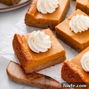 Pumpkin Gooey Butter Cake Recipe — Decadent Fall Dessert 13 Slices of pumpkin gooey butter cake topped with whipped cream.