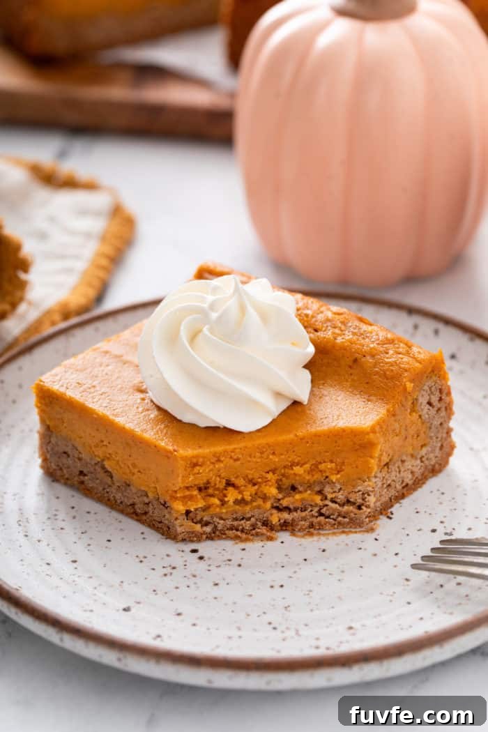 Pumpkin Gooey Butter Cake Recipe — Decadent Fall Dessert 4 Bite cut from the corner of a plated slice of pumpkin gooey butter cake.