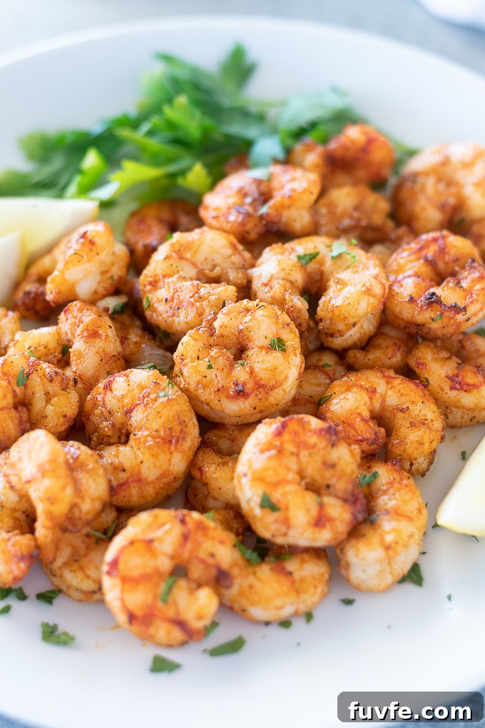 Air fryer shrimp on a plate with lemon and parsley
