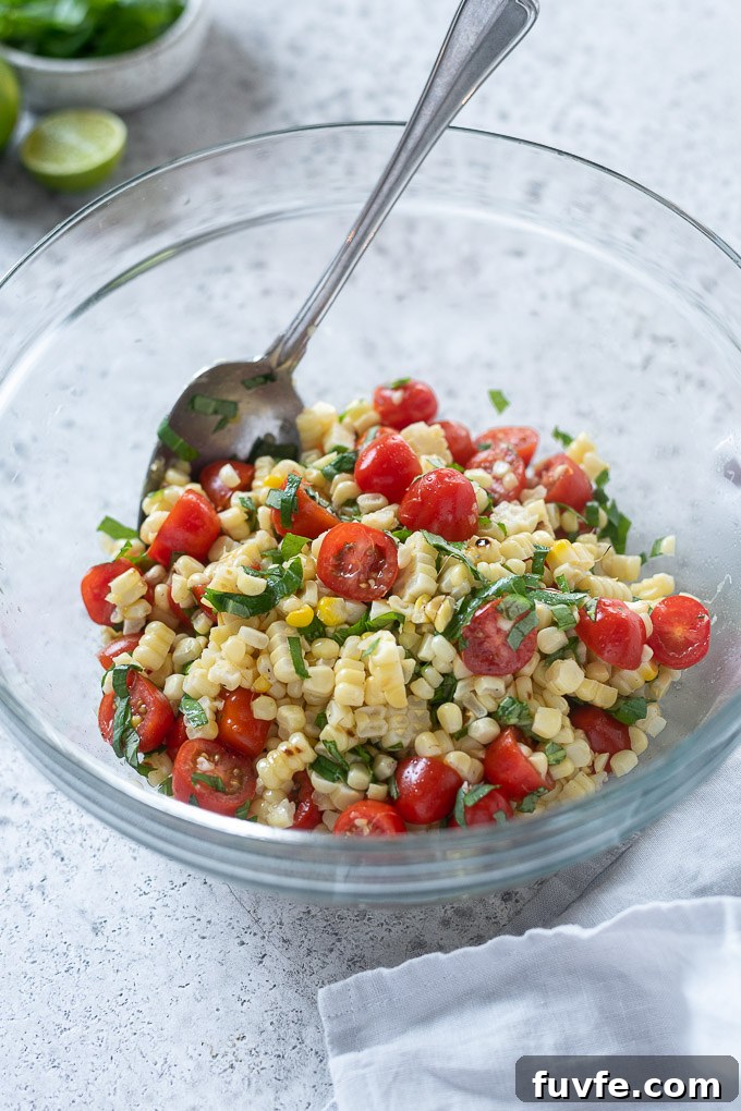 Tomato corn salad tossed in mixing bowl