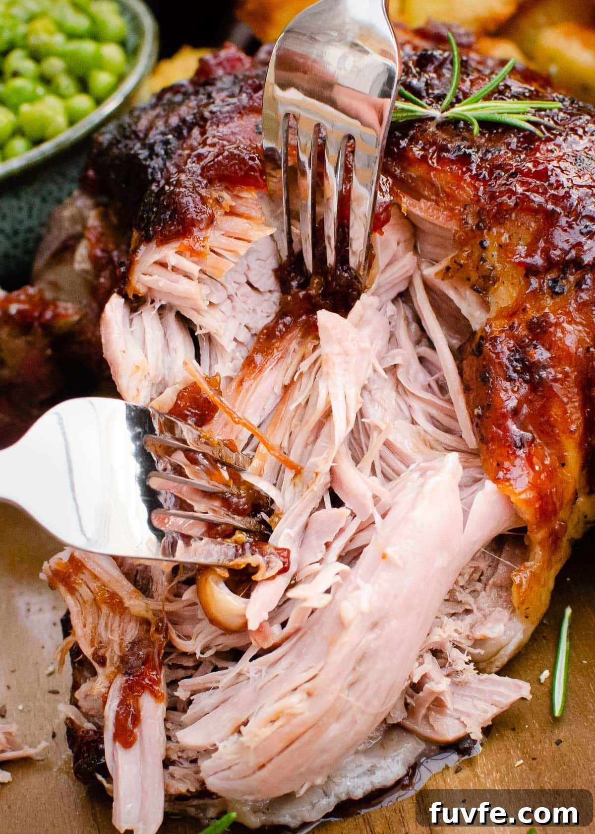 Slow roast leg of lamb being pulled apart with two forks
