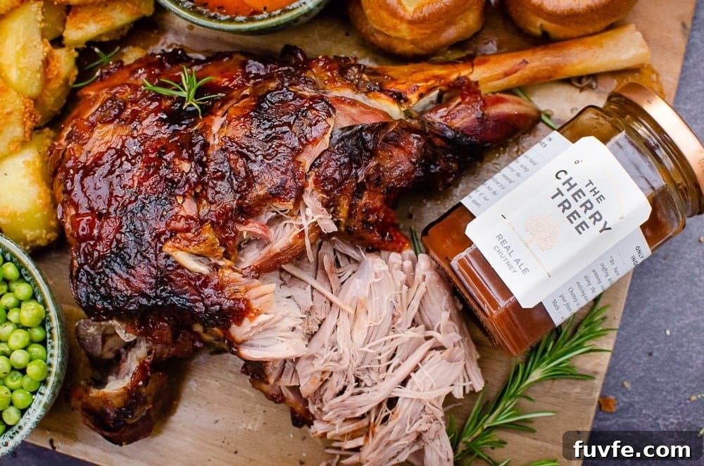 Slow Cooked Leg of Lamb on a wooden chopping board with a jar of the cherry tree real ale chutney