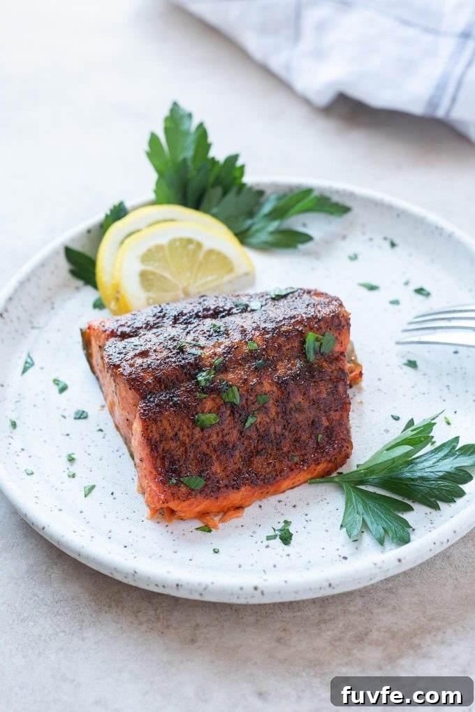 Air fryer salmon on a plate with lemon and parsley