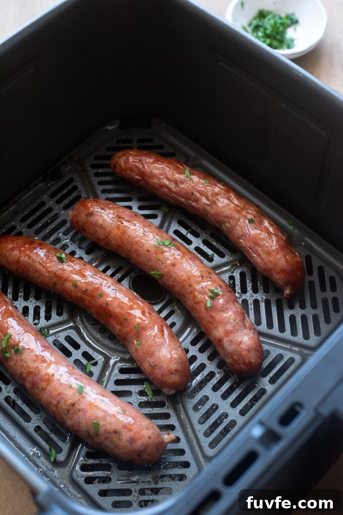 Air fried sausage in air fryer basket.
