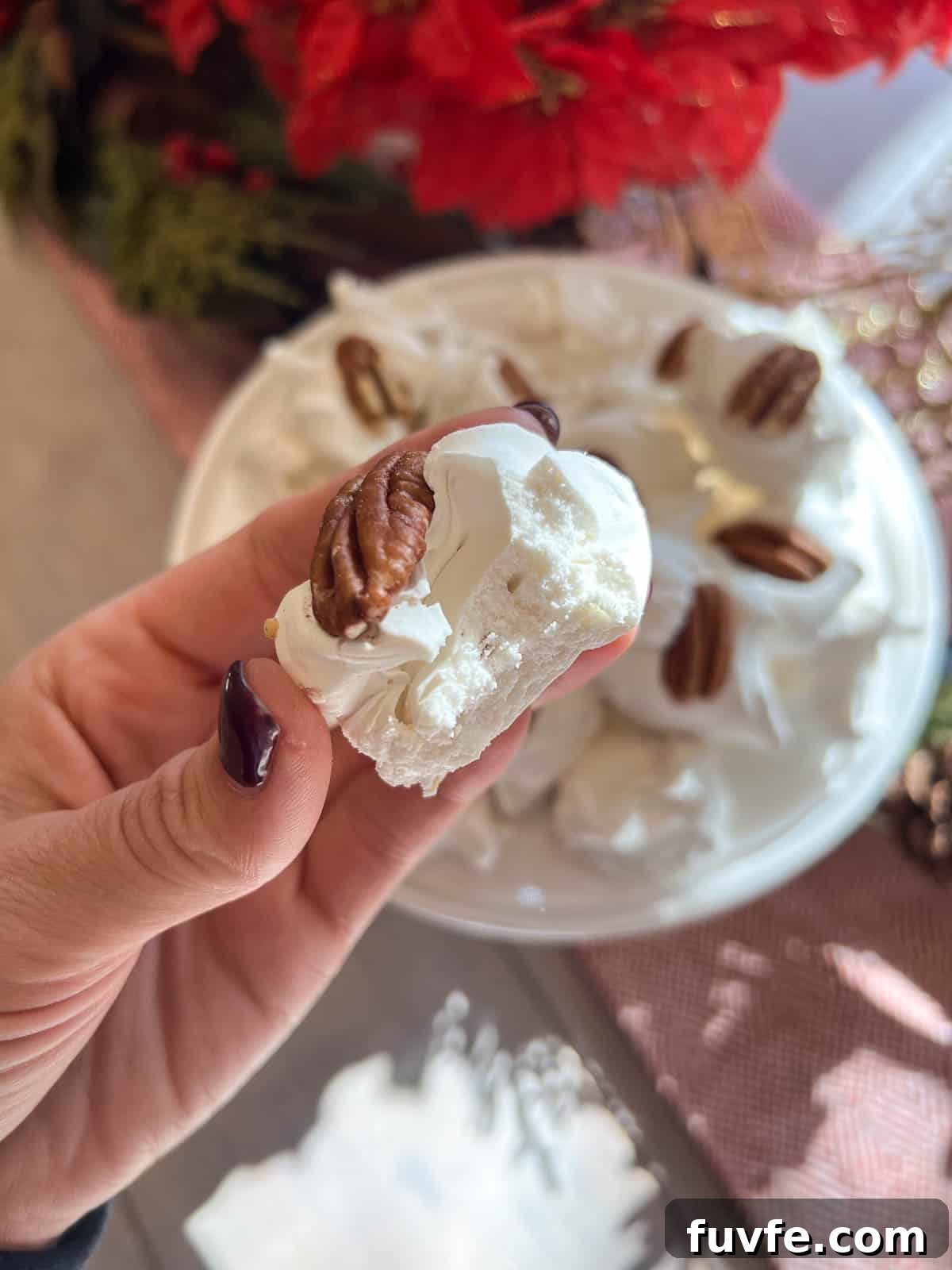 classic divinity candy in a hand with a pecan on top
