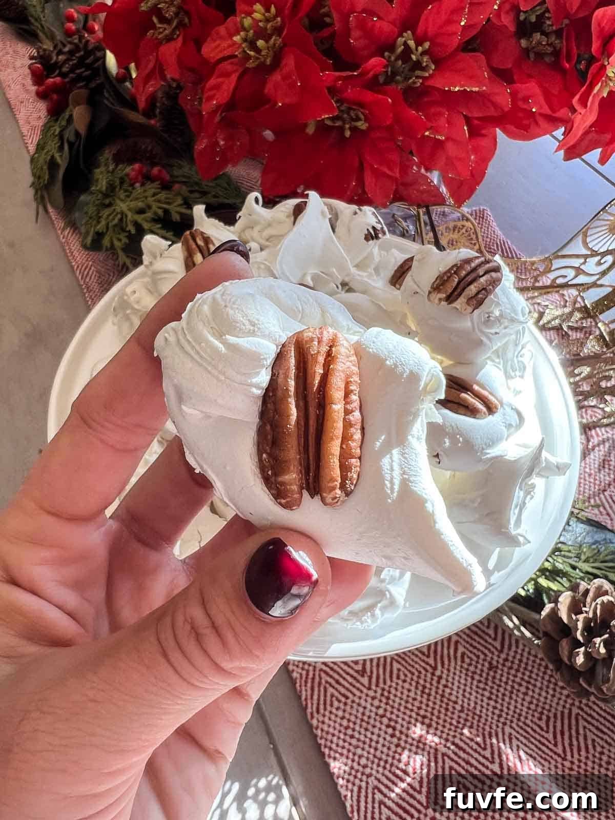 classic divinity candy in a hand with a pecan on top