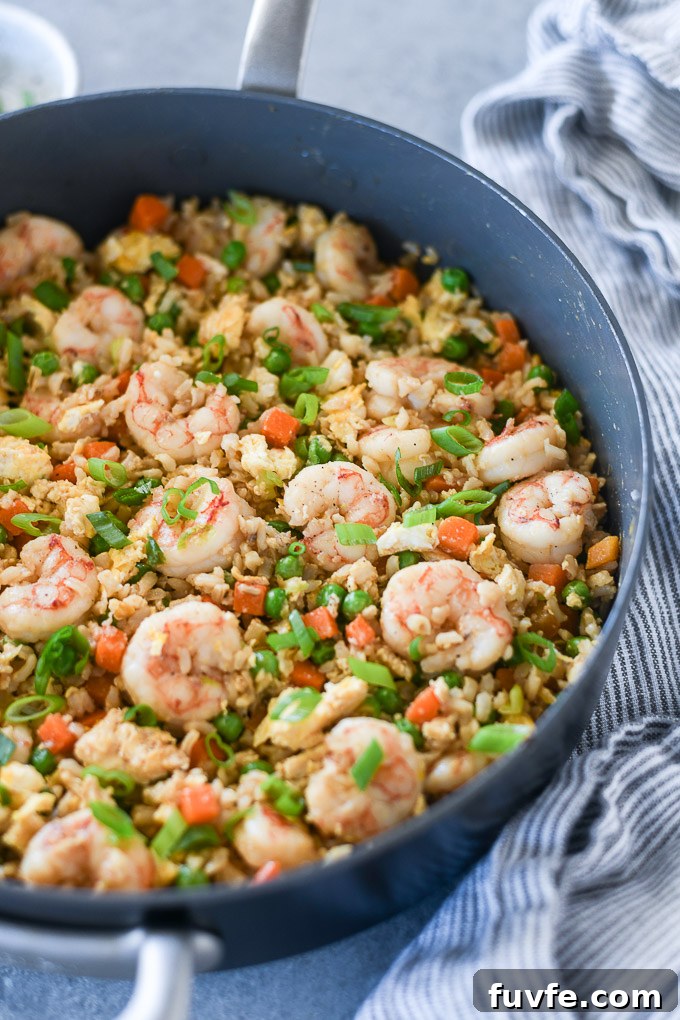 Authentic Shrimp Fried Rice Recipe with Garlic and Scallions 6 Shrimp fried rice in pan with linen alongside
