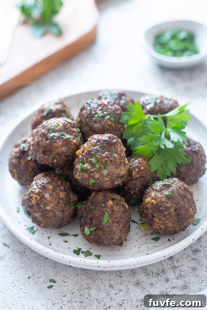 Crispy Air Fryer Meatballs Recipe 3 Air fryer meatballs piled up on a white plate