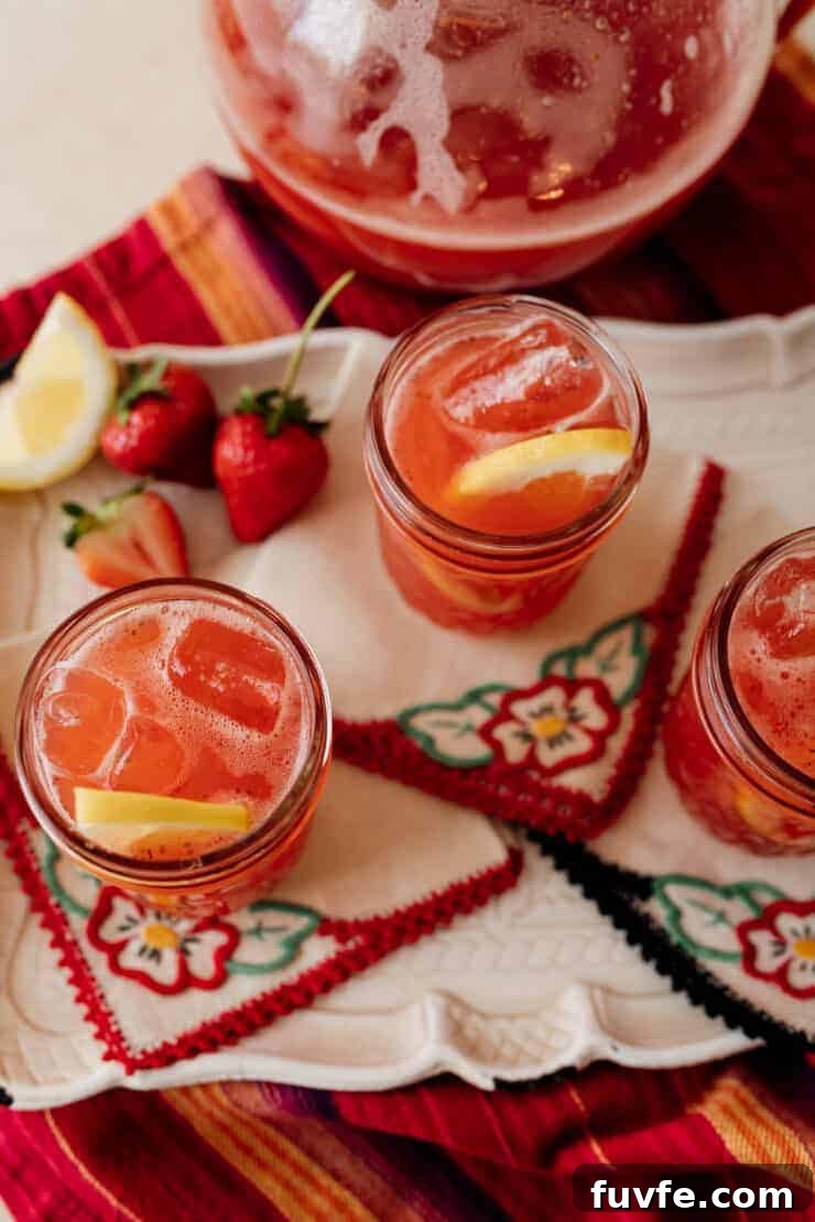 close up shot of strawberry sweet tea in a mason jar garnished with a fresh lemon slice