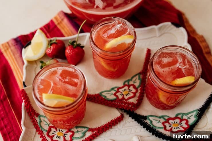 three mason jars of strawberry sweet tea on hand embroidered cocktail napkins