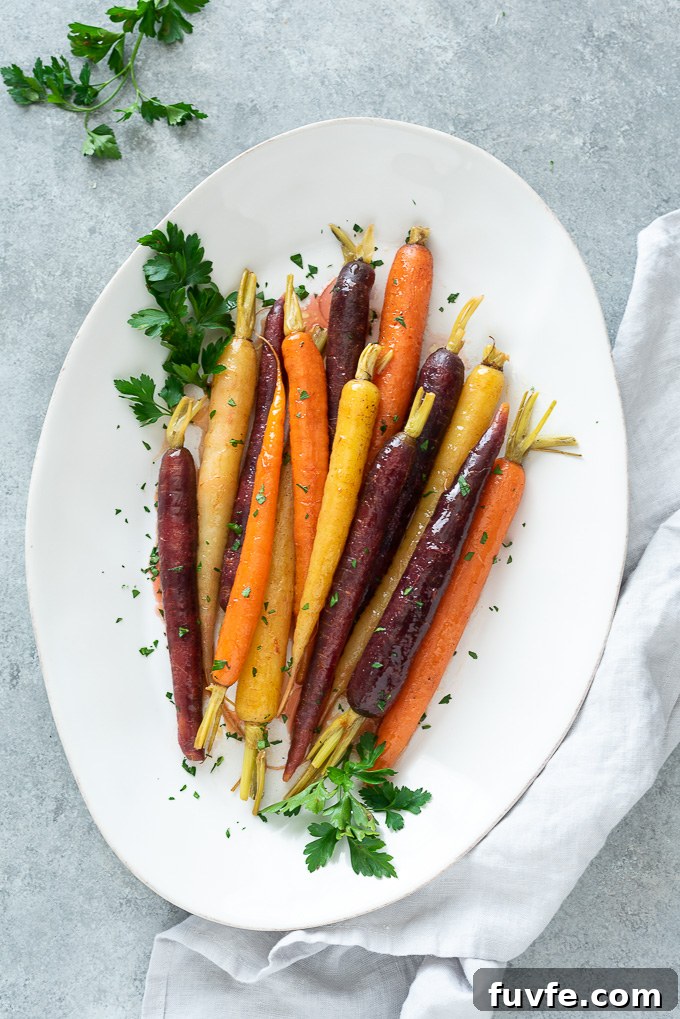 Glazed carrots on a white serving dish with a linen alongside