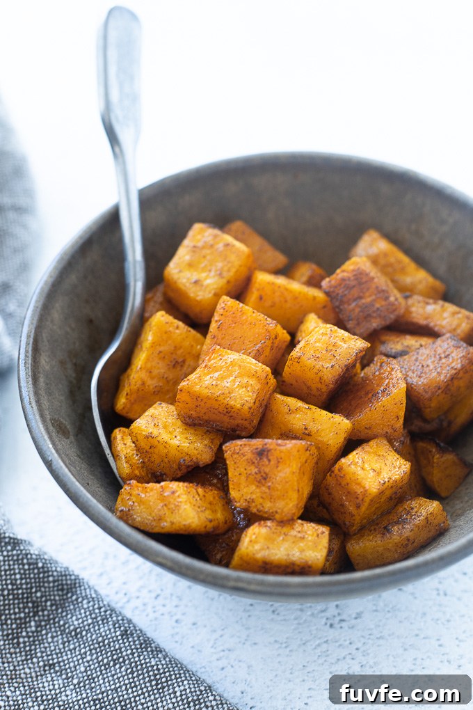 Cinnamon roasted butternut squash in a bowl with a spoon