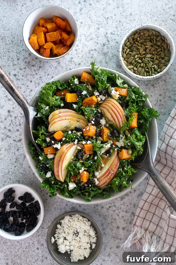 Harvest fall salad in a bowl with salad servers digging in