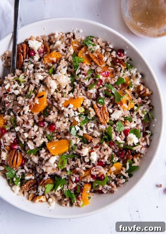 Wild rice salad in a white bowl with a serving spoon