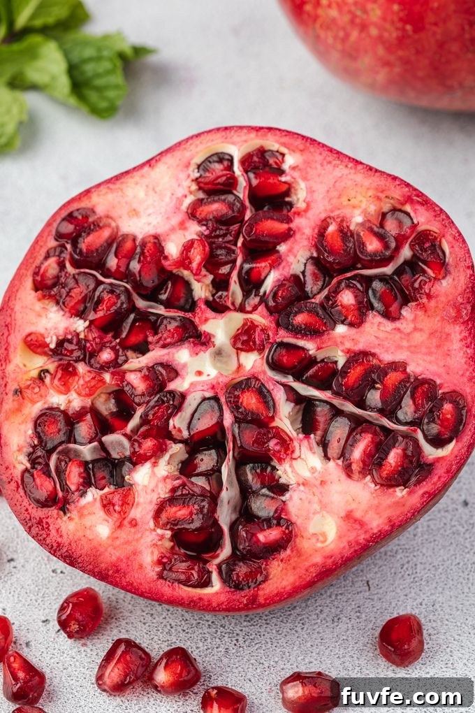 How to Cut and Remove Pomegranate Seeds 8 Half of a pomegranate with arils around it