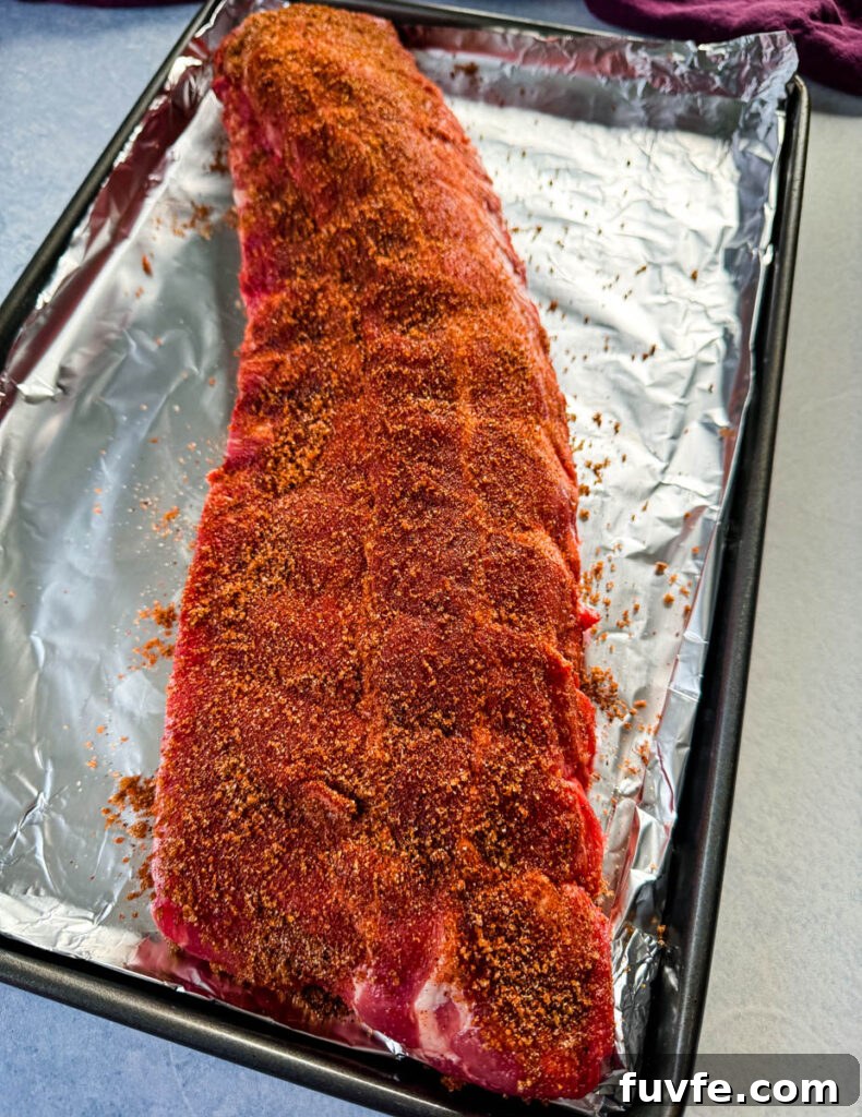 dry rub for ribs on a rack of ribs on a platter with foil