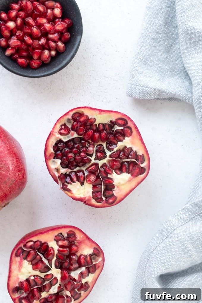 Halved pomegranate and arils in a bowl