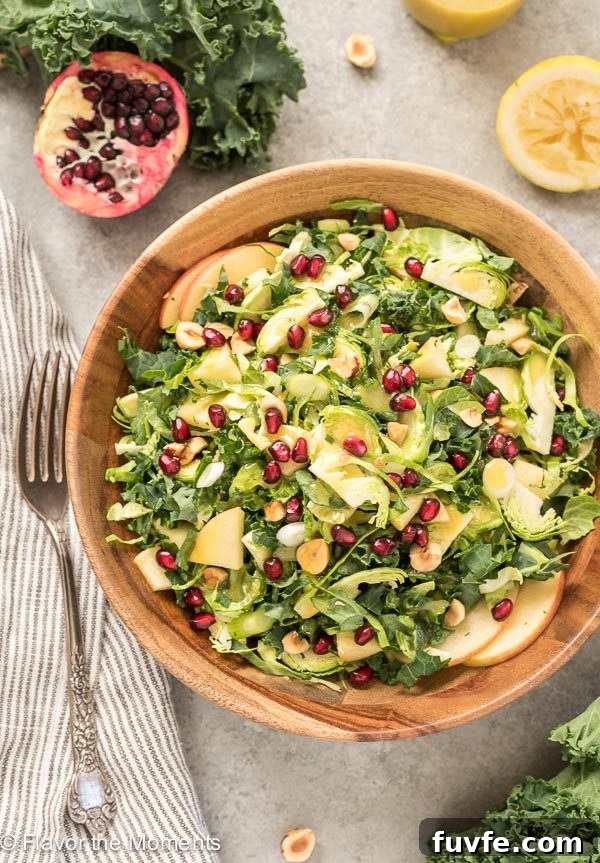 45 Pomegranate Recipes and Complete Produce Guide 11 Kale Brussels Sprout Salad in teak bowl with pomegranates on top