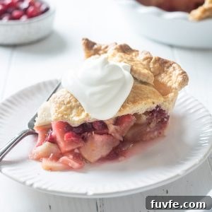 Slice of apple cranberry pie with whipped cream