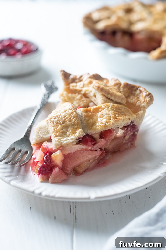 Slice of apple cranberry pie on a plate