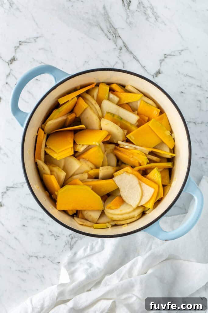 Grandma’s Creamy Pumpkin Soup Recipe 6 Adding the sliced pumpkin and potatoes to the pot.