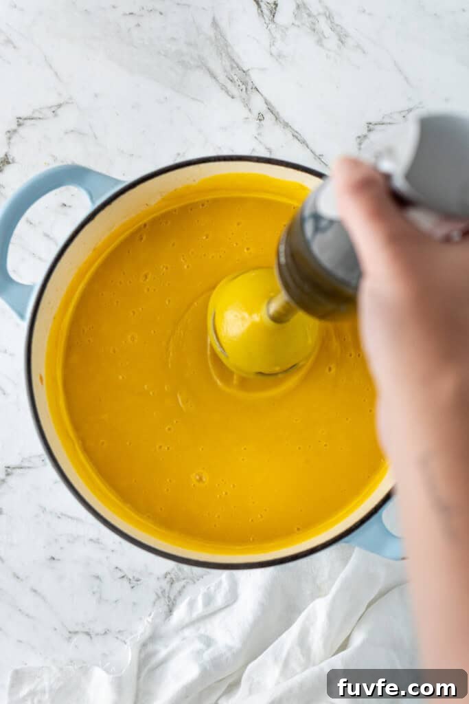 Grandma’s Creamy Pumpkin Soup Recipe 9 Blending the soup in a pot with a stick blender.