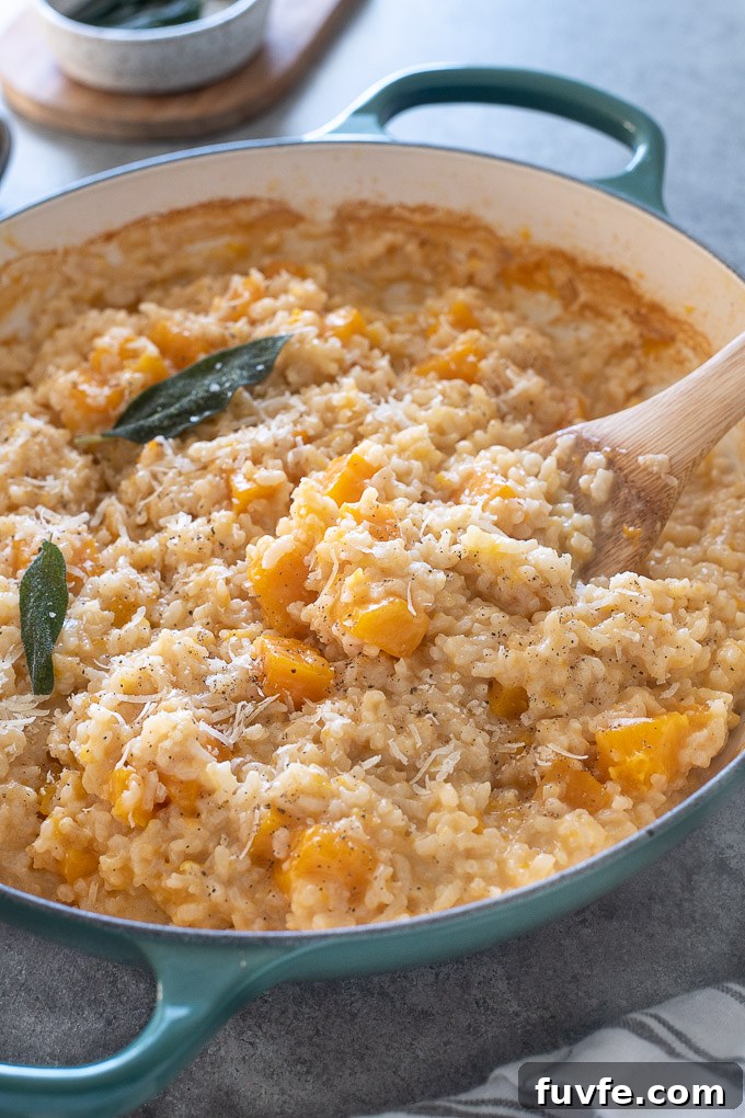 Wooden spoon in pan of butternut squash risotto