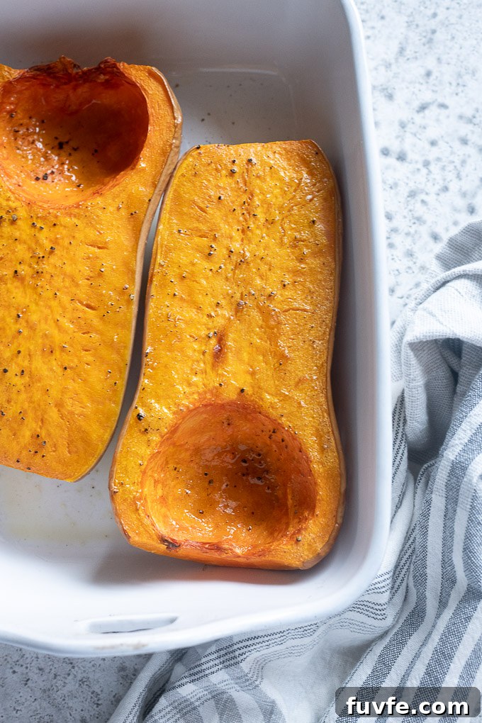 Roasted butternut squash halves in a baking dish