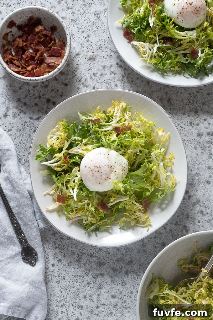Plates of salad lyonnaise with bacon and frisee in bowls