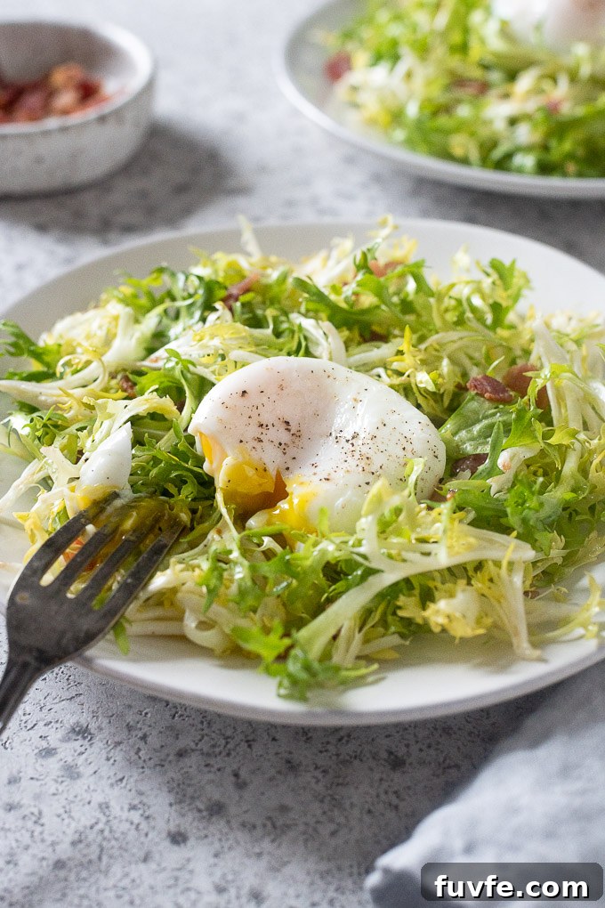 salade lyonnaise with fork breaking yolk
