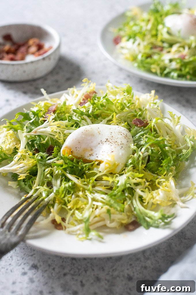 Lyonnaise salad on a plate with broken egg yolk